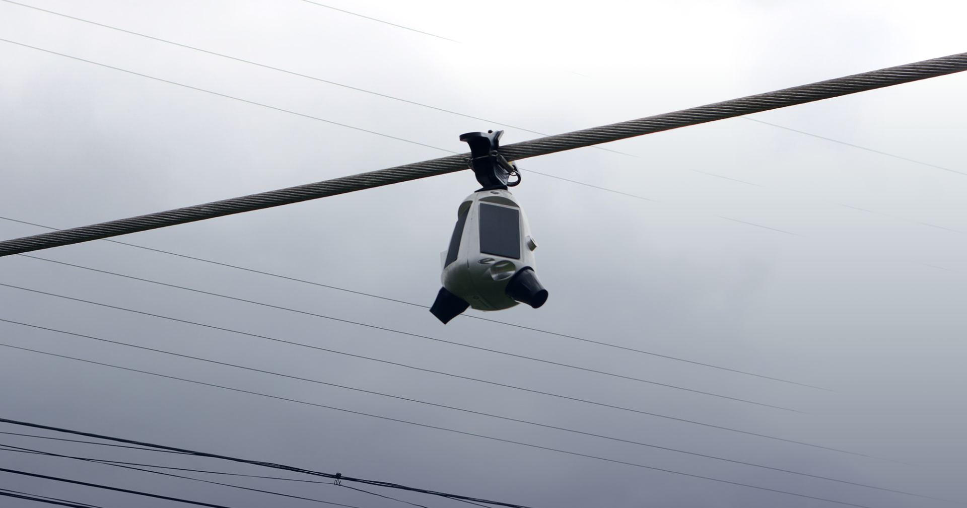 Image of a sentri device hanging from a power line